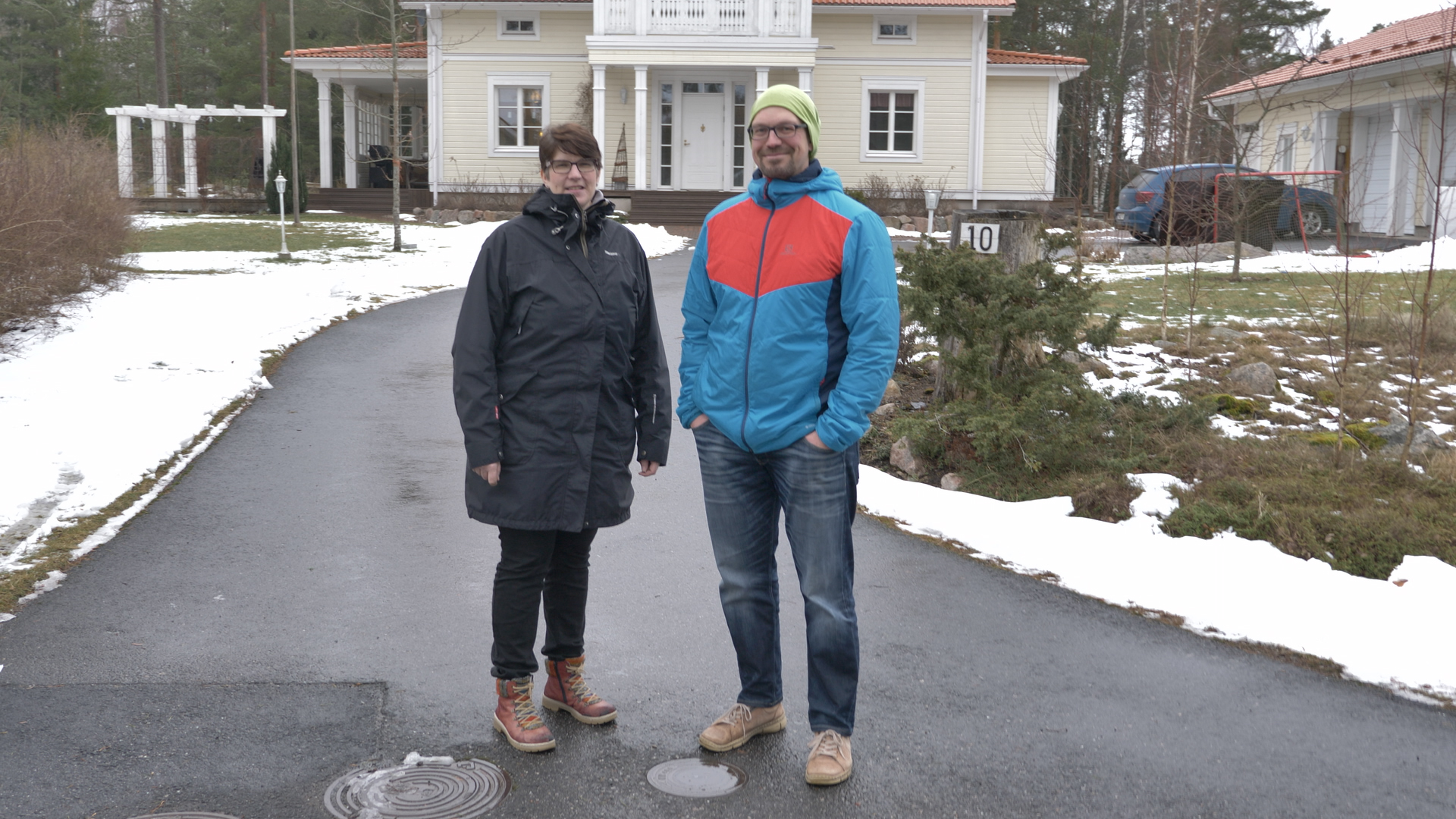 Ett par står utanför ett egnahemshus i Nagu på vintern.